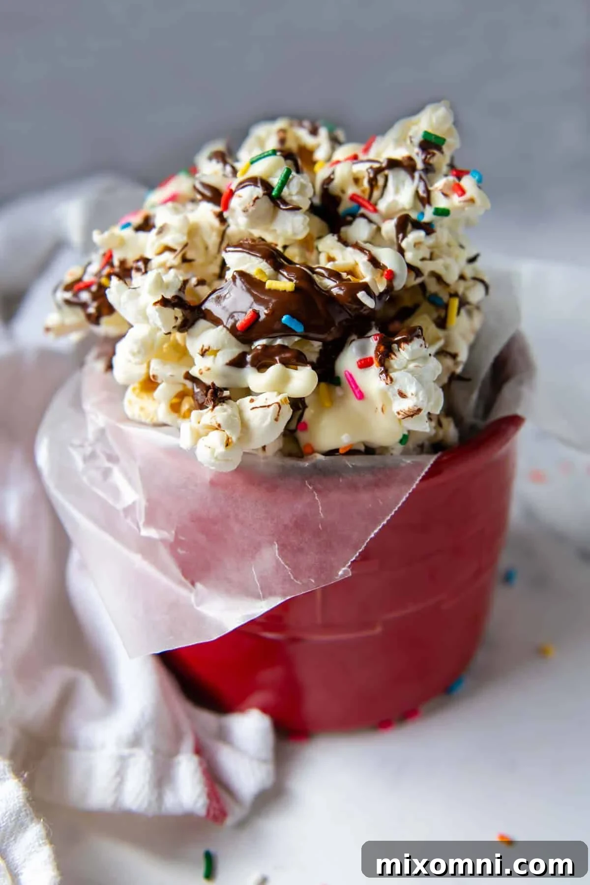 Close-up of chocolate popcorn generously coated with colorful sprinkles, ready to be enjoyed.
