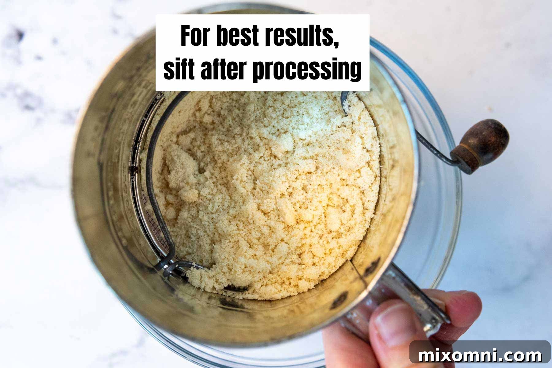 A sifter with fine almond flour being processed through it, showing the airy texture.