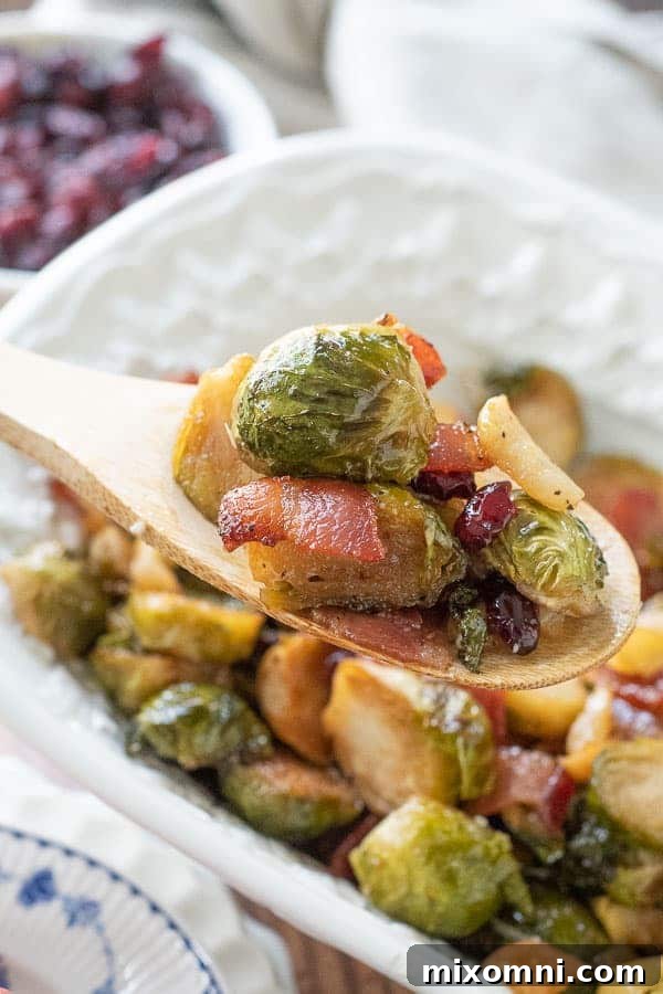 A wooden spoon delicately lifts a scoop of crispy bacon and caramelized Brussels sprouts, highlighting the rich textures and appealing colors.