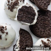 A gluten-free Oreo ball cut in half, revealing its creamy center and chocolate coating, presented as the recipe hero image.