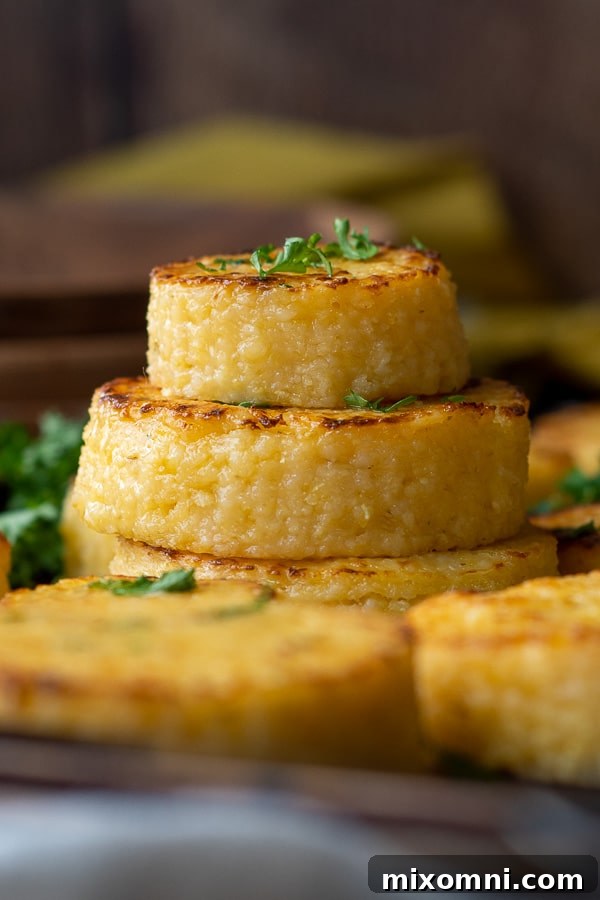 A stack of golden, crispy cheese grit cakes garnished with fresh parsley.