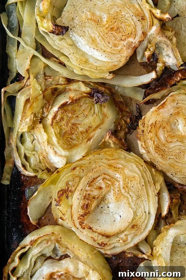 An overhead shot of beautifully crispy oven-roasted cabbage steaks on a baking sheet, golden-brown at the edges.