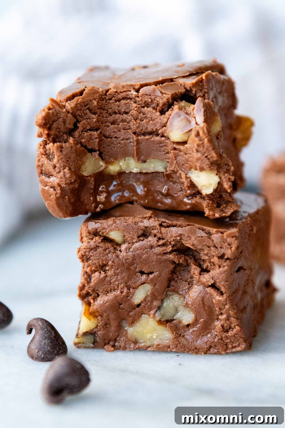 a stack of 2 pieces of fudge with the top one having a bite out.