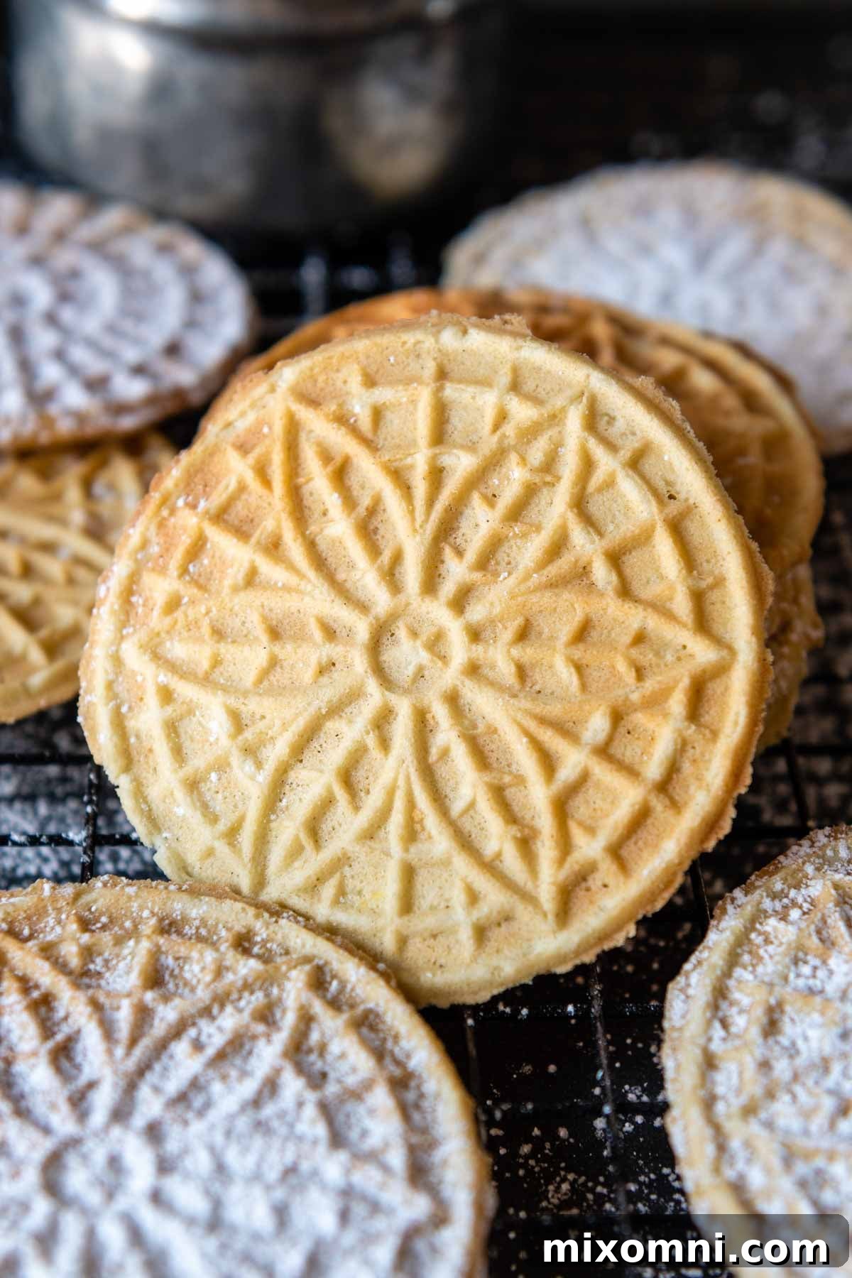 a gluten-free pizzelle leaning up against a stack with others around it.
