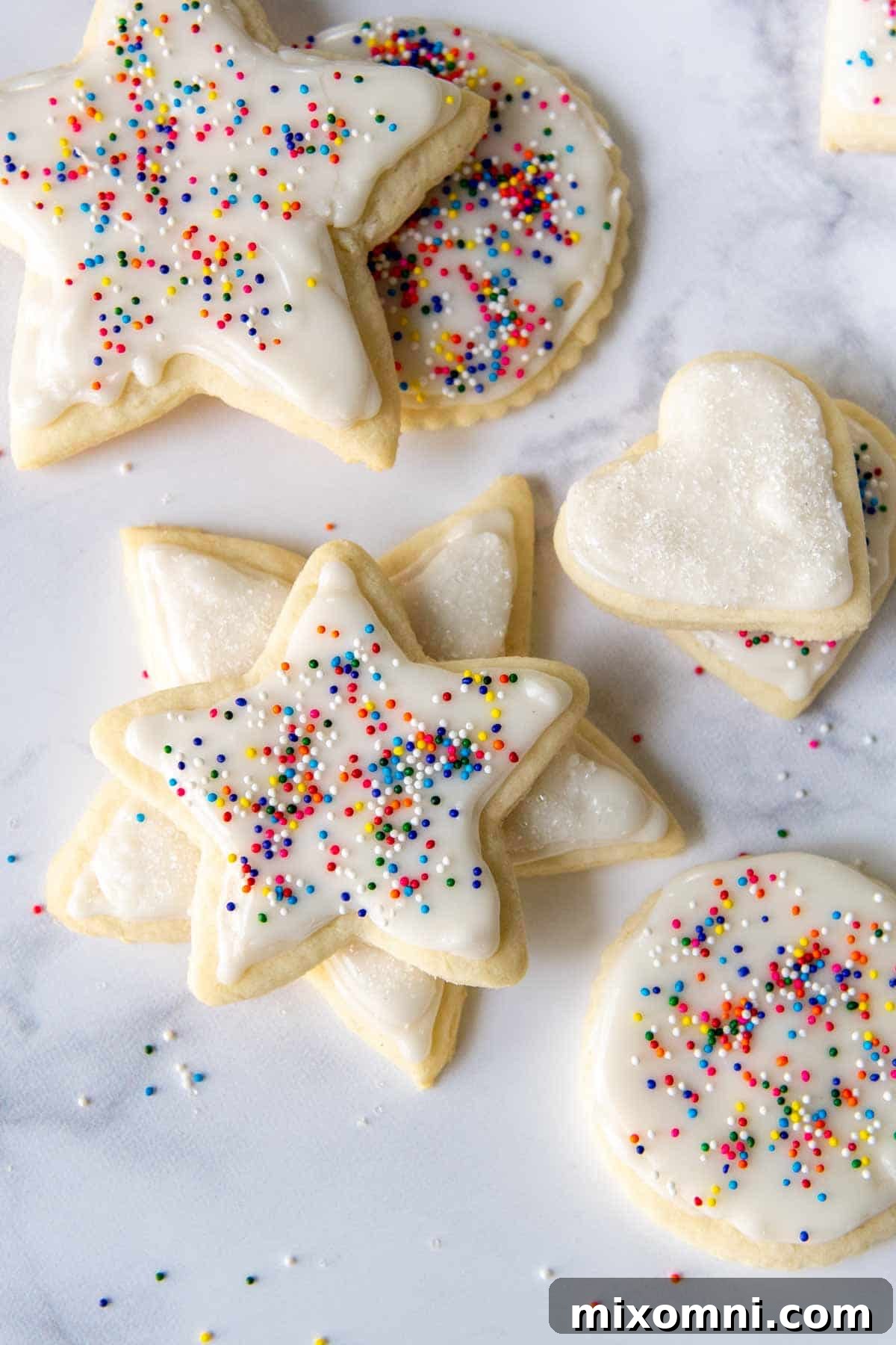 cut out cookies with white frosting and sprinkles
