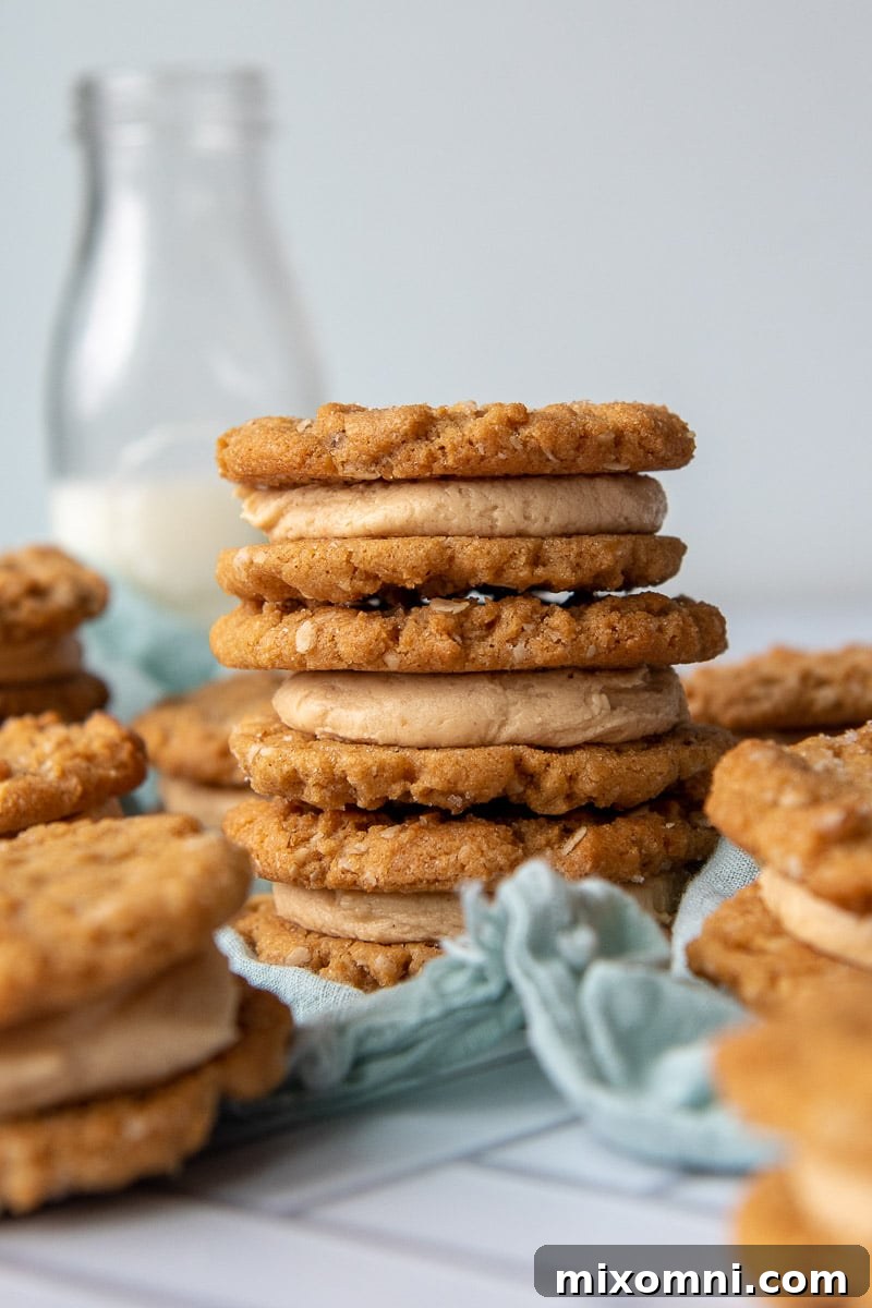 a stack of three cookie sandwiches with a milk bottle in background