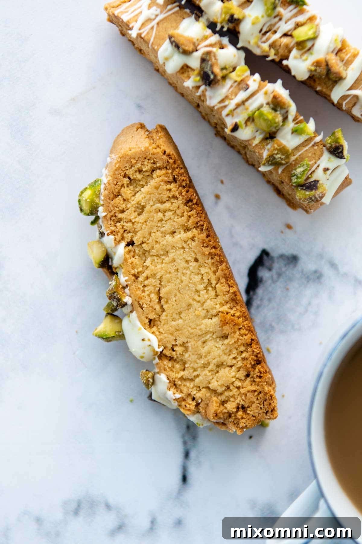 a face up slice of biscotti with a cup of coffee in the corner of the frame