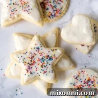 cut out cookies with white frosting and sprinkles