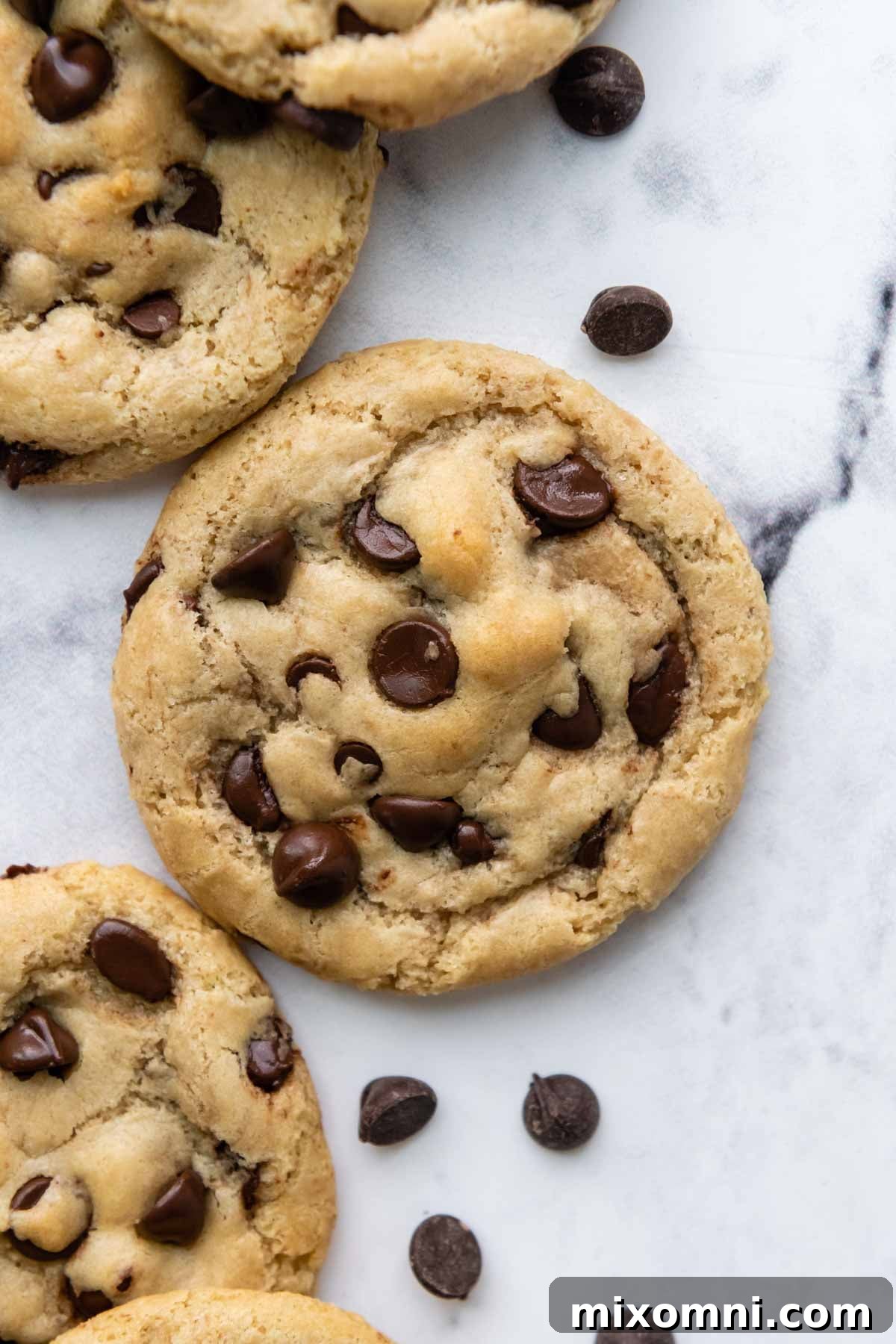 overhead shot of chocolate chip cookies with chocolate chips next to them.