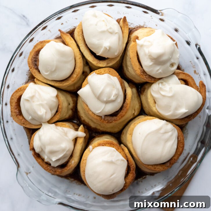 the frosting dolloped on the baked rolls.