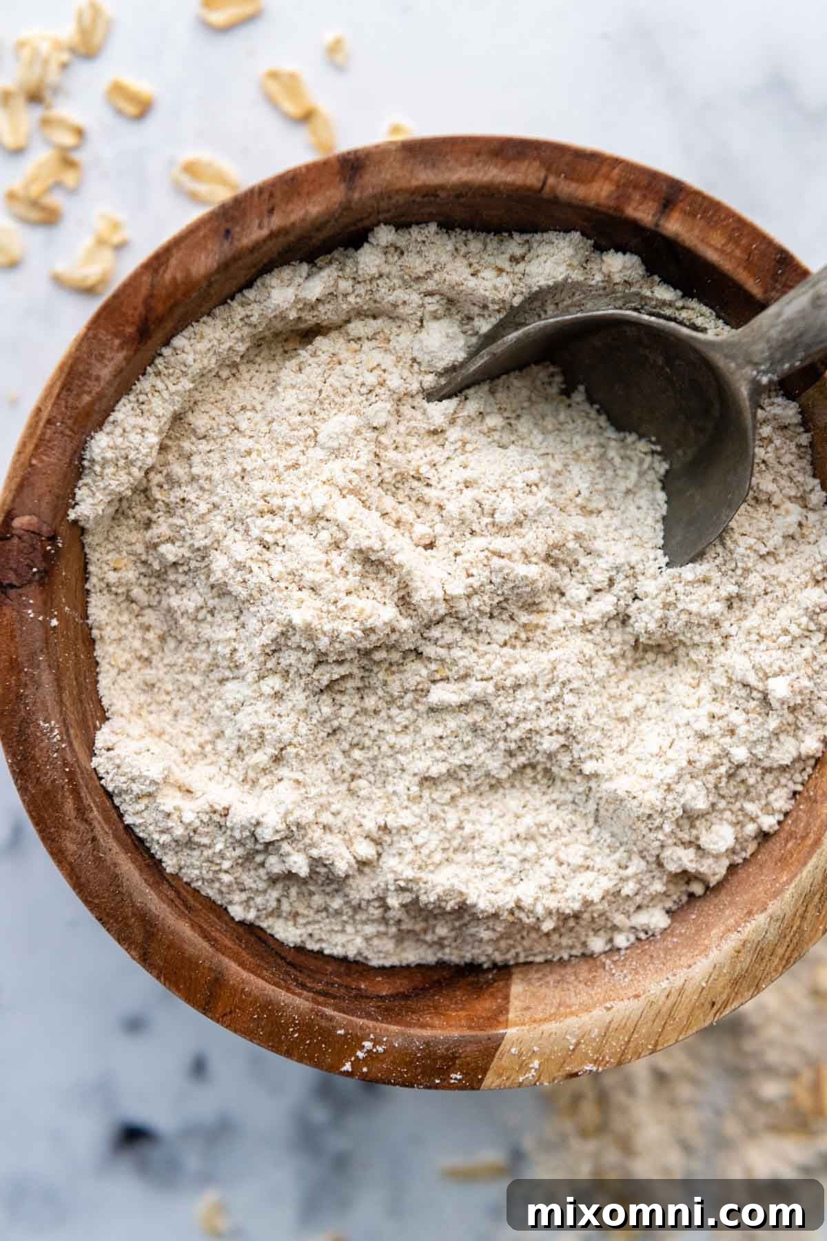 a bowl of oat flour with a scoop in it.