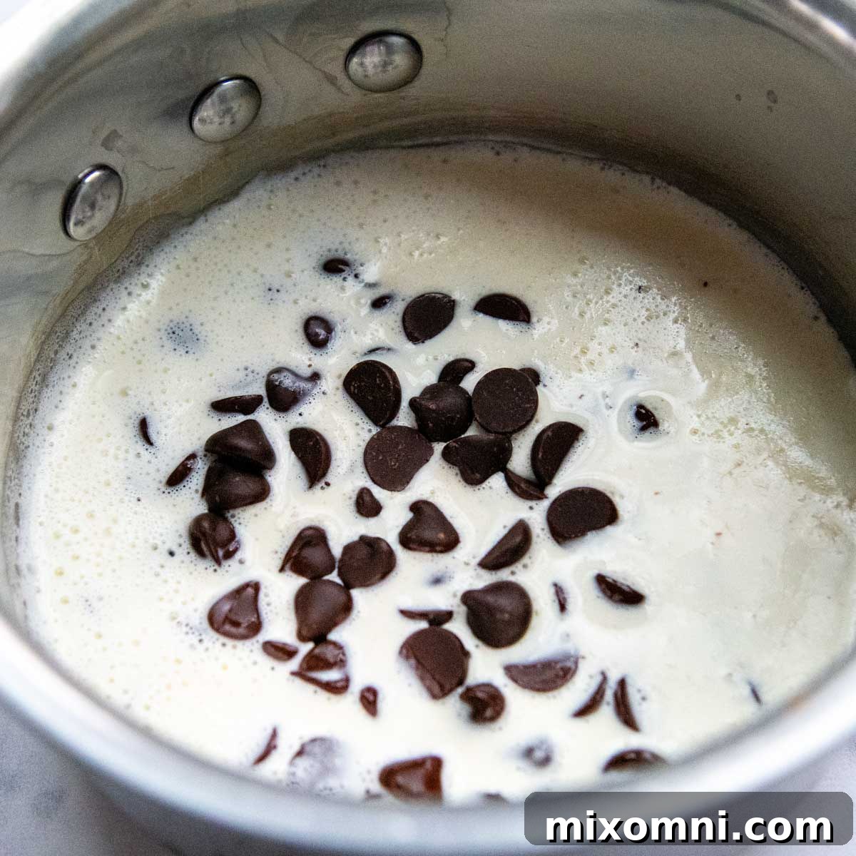 chocolate chips being melted in heavy cream