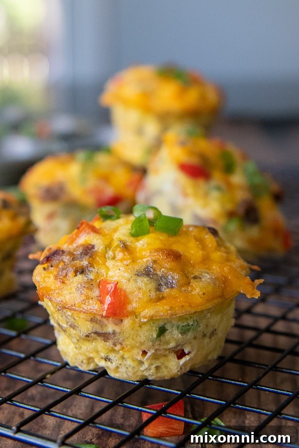 A close-up view of a baked breakfast egg muffin cooling on a wire rack.
