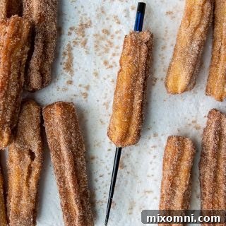 a chopstick going through cooked churros to make an opening for filling