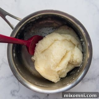 a ball of gluten free churro dough in a saucepan