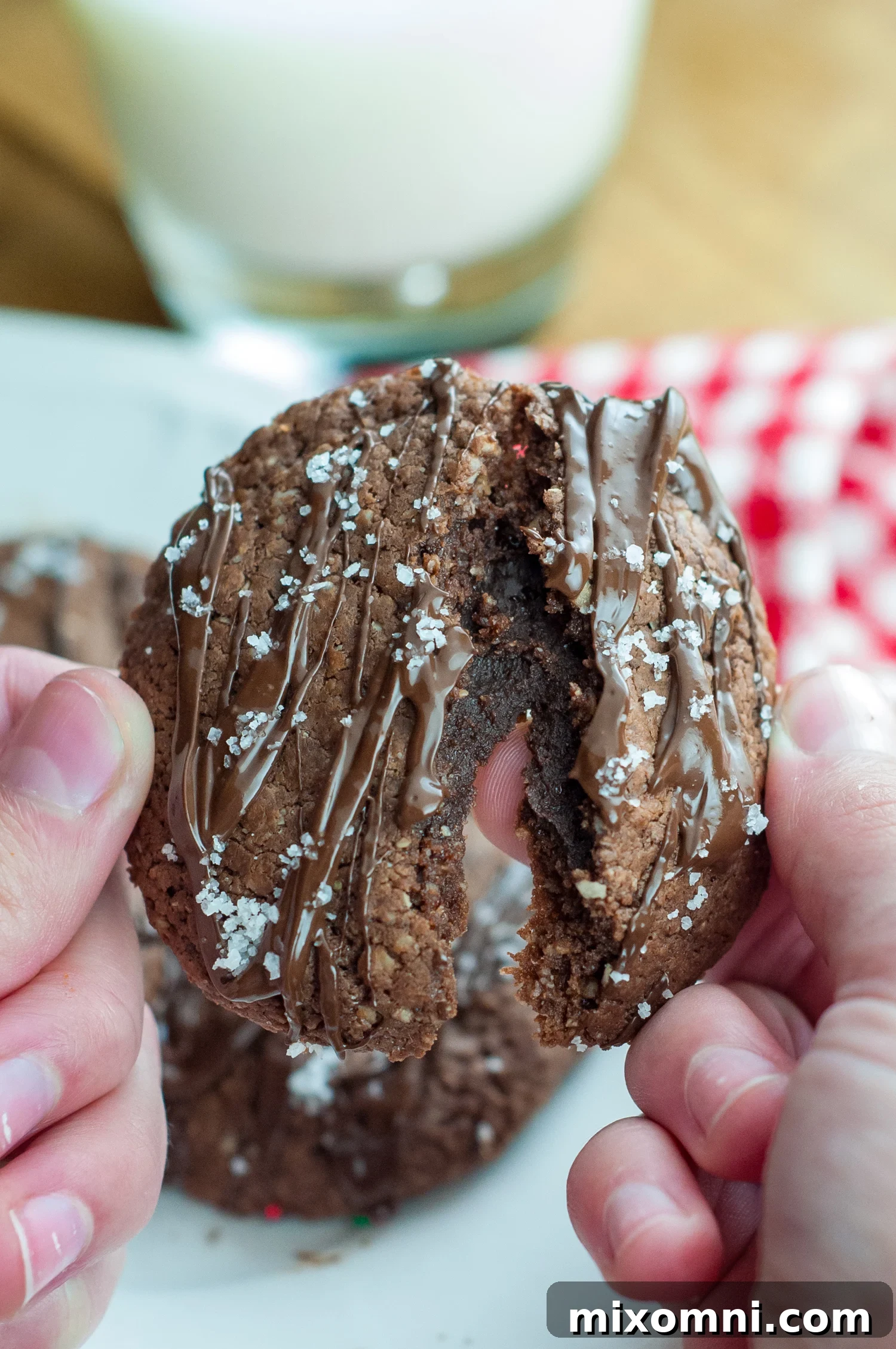 A fudgy Nutella cookie being split apart, revealing its soft, rich center.