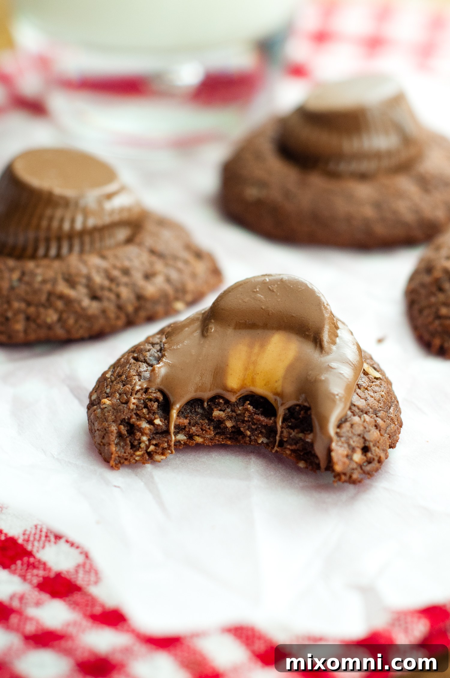 A warm Nutella cookie with a melting peanut butter cup pressed into its top.