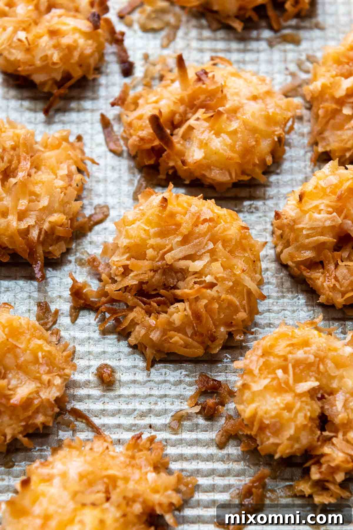 Freshly baked gluten-free coconut shrimp arranged beautifully on a baking sheet, showcasing their golden, crispy texture right out of the oven.