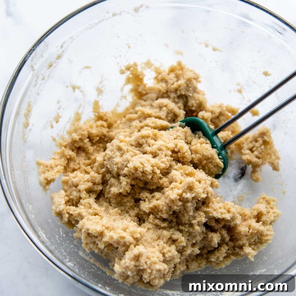 Almond flour pizza dough in a bowl immediately after mixing, appearing somewhat wet.