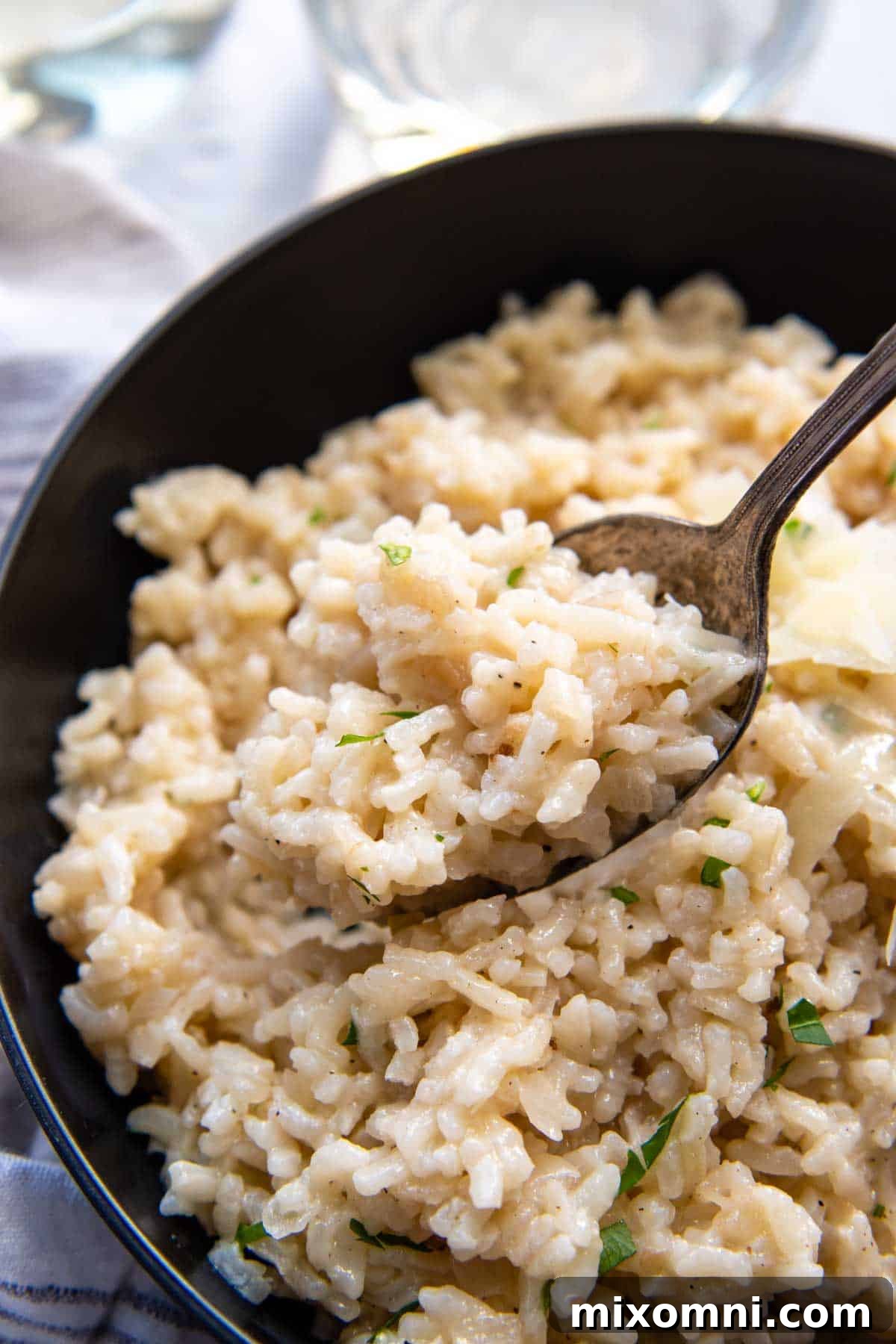 A spoon lifting a creamy bite of gluten-free risotto, perfectly cooked and ready to enjoy.