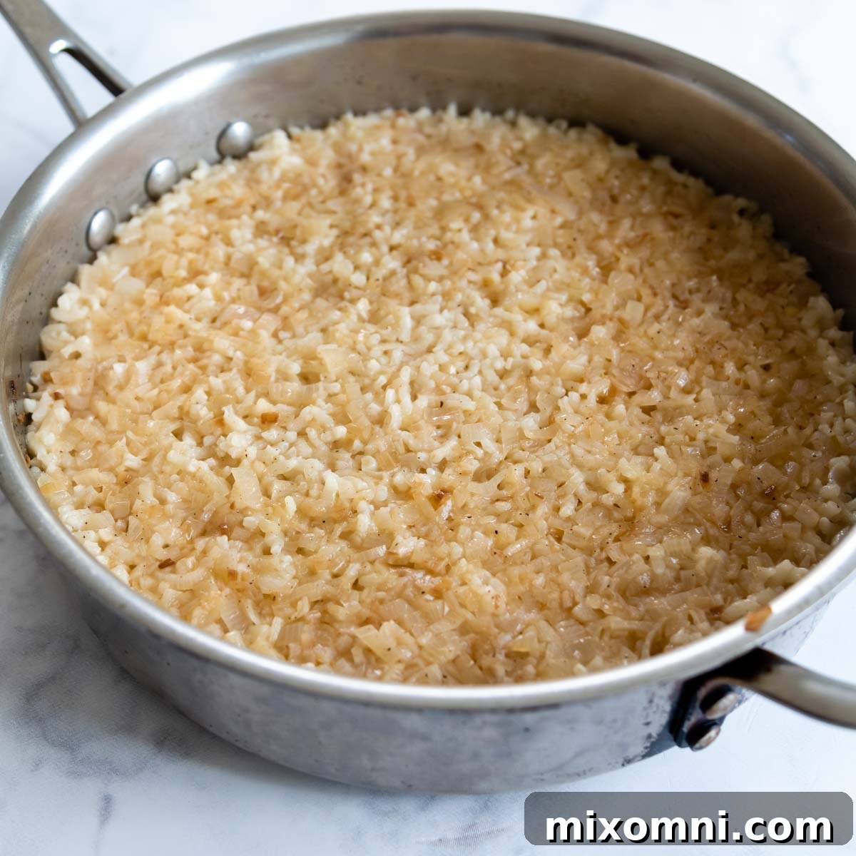 The creamy, perfectly cooked gluten-free risotto in a pan after being removed from the oven, with most of the liquid absorbed.