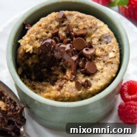 A bite taken out of the cake with a spoon resting next to it.