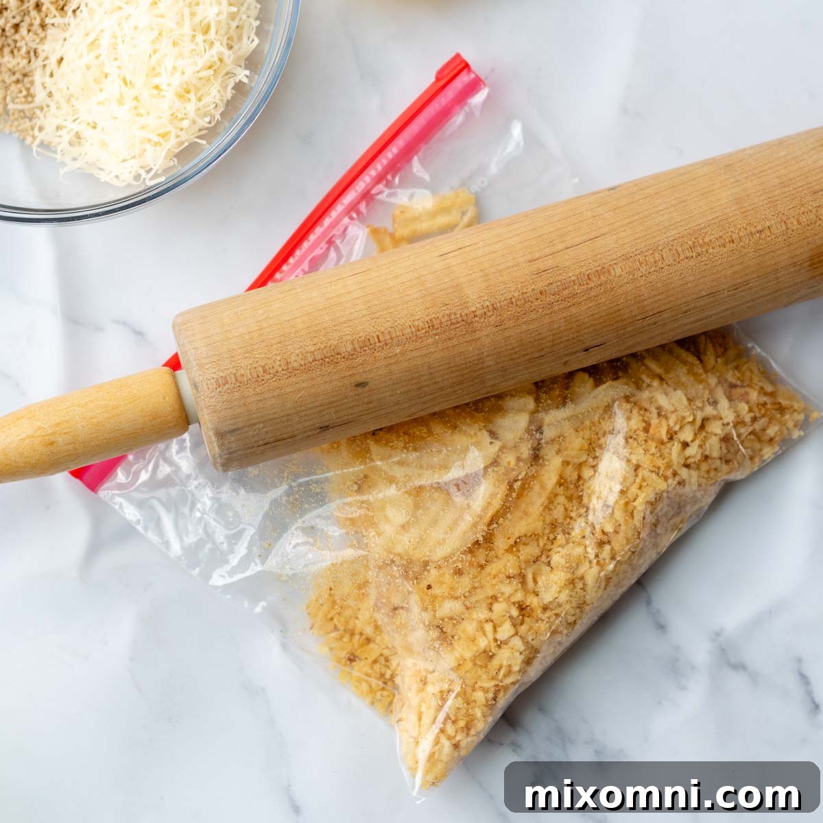 A rolling pin crushing potato chips and cereal in a plastic bag.