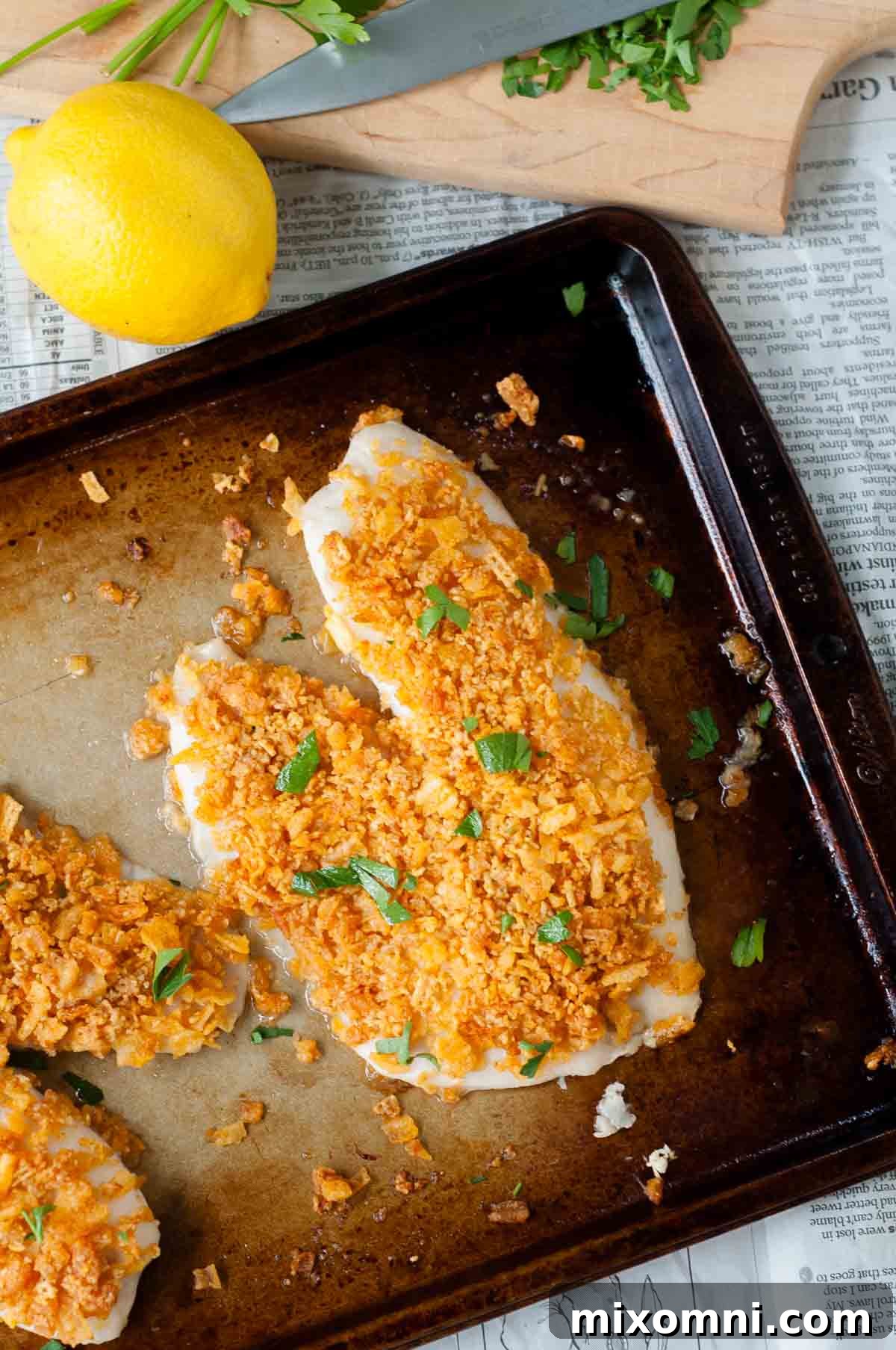 An overhead shot of golden-brown crispy baked fish fillets on a baking sheet, ready to be served.