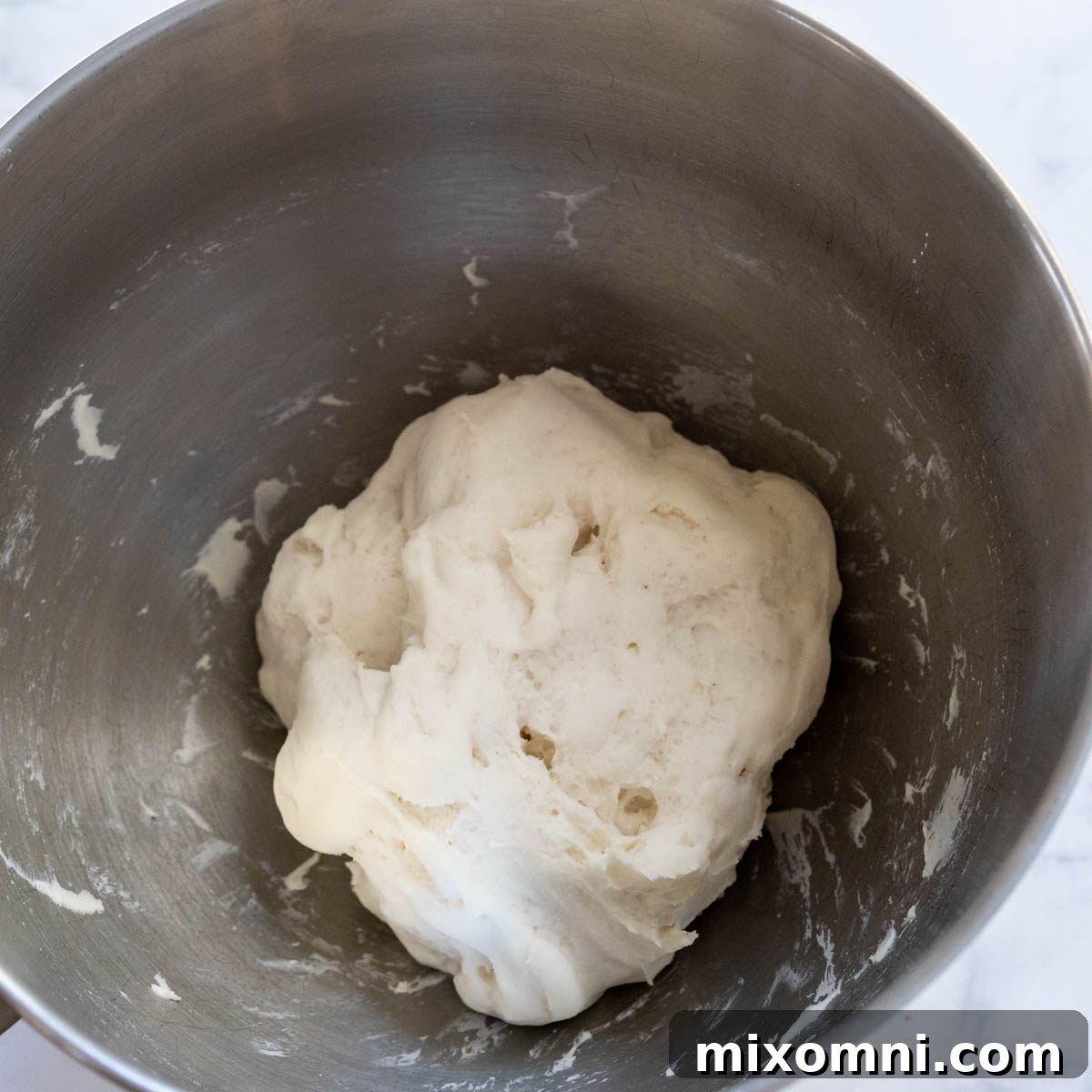 Gluten-free flatbread dough after rising, showing a noticeable increase in volume and airiness.