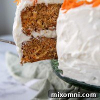 Close up of a moist slice of old-fashioned carrot cake being taken from a cake stand.