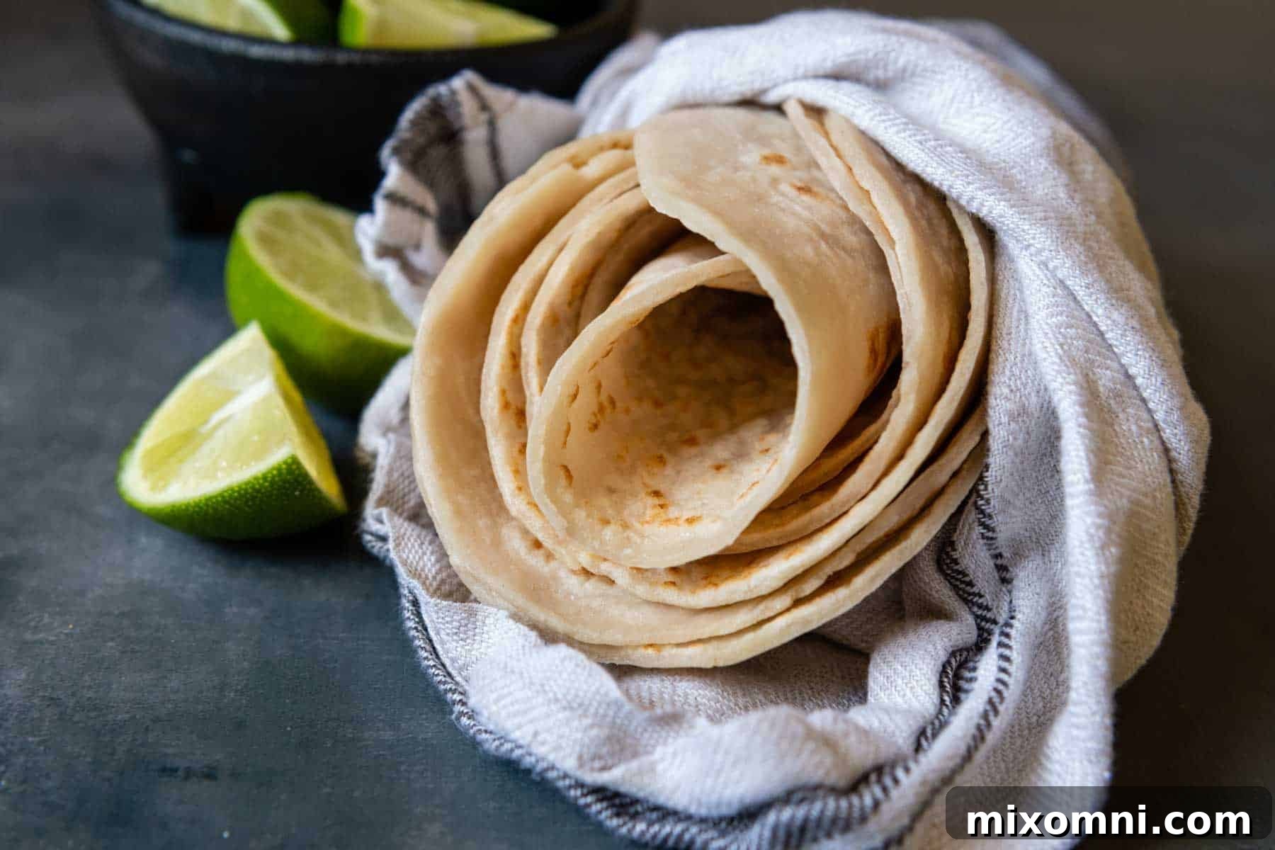 Warm gluten-free tortillas wrapped snugly in a clean kitchen towel, signifying readiness for serving or storage.