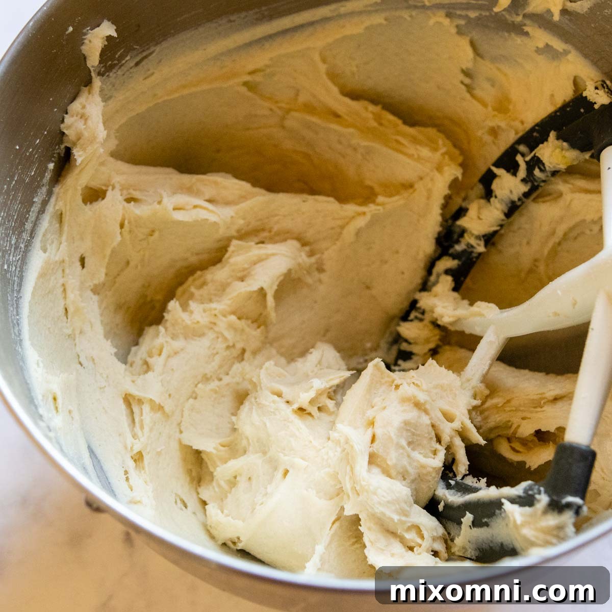 The smooth and pliable gluten-free hot dog bun dough in a stand mixer bowl, ready for shaping.