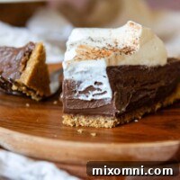 A bite of chocolate tart on a wooden plate, highlighting the perfectly structured gluten-free graham cracker crust.
