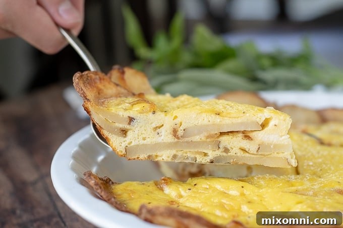 A close-up shot of a spatula carefully lifting a slice of golden potato frittata.