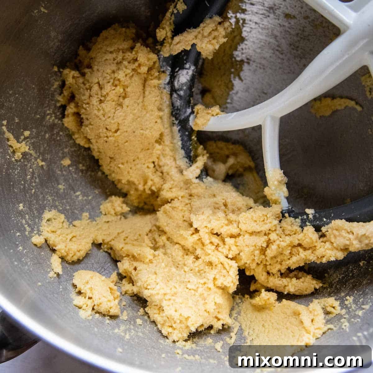 Thick cake batter being mixed in a bowl, showing the consistency before adding egg whites.