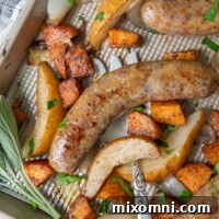 A close-up overhead shot of baked Italian sausage on a baking sheet with a large serving fork underneath