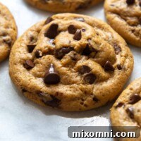 A delicious gluten-free pumpkin cookie with chocolate chips on a white marble surface, showcasing its chewy texture.