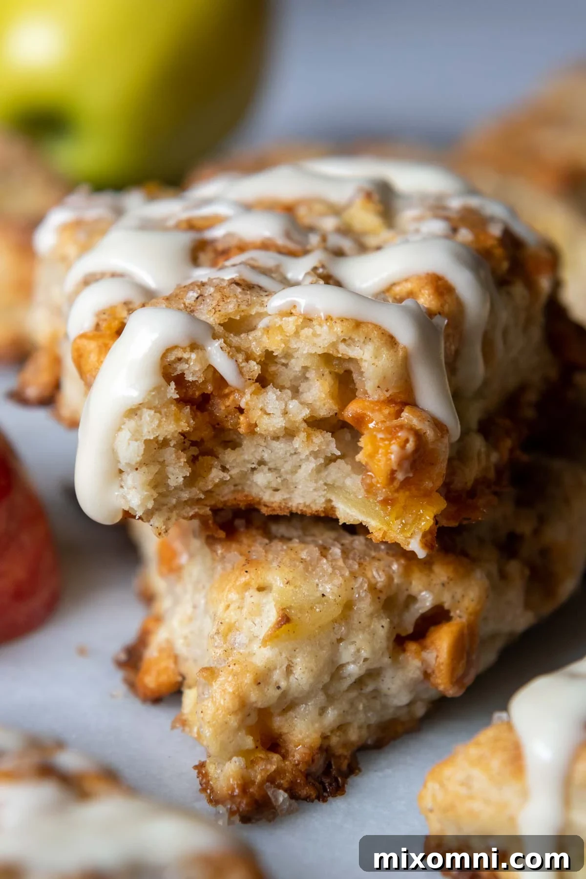 A perfectly baked gluten-free apple scone with a bite taken out, showcasing its tender crumb and apple pieces.