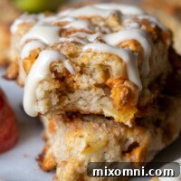 A perfectly baked gluten-free apple scone with a bite taken out, showcasing its tender crumb and apple pieces.