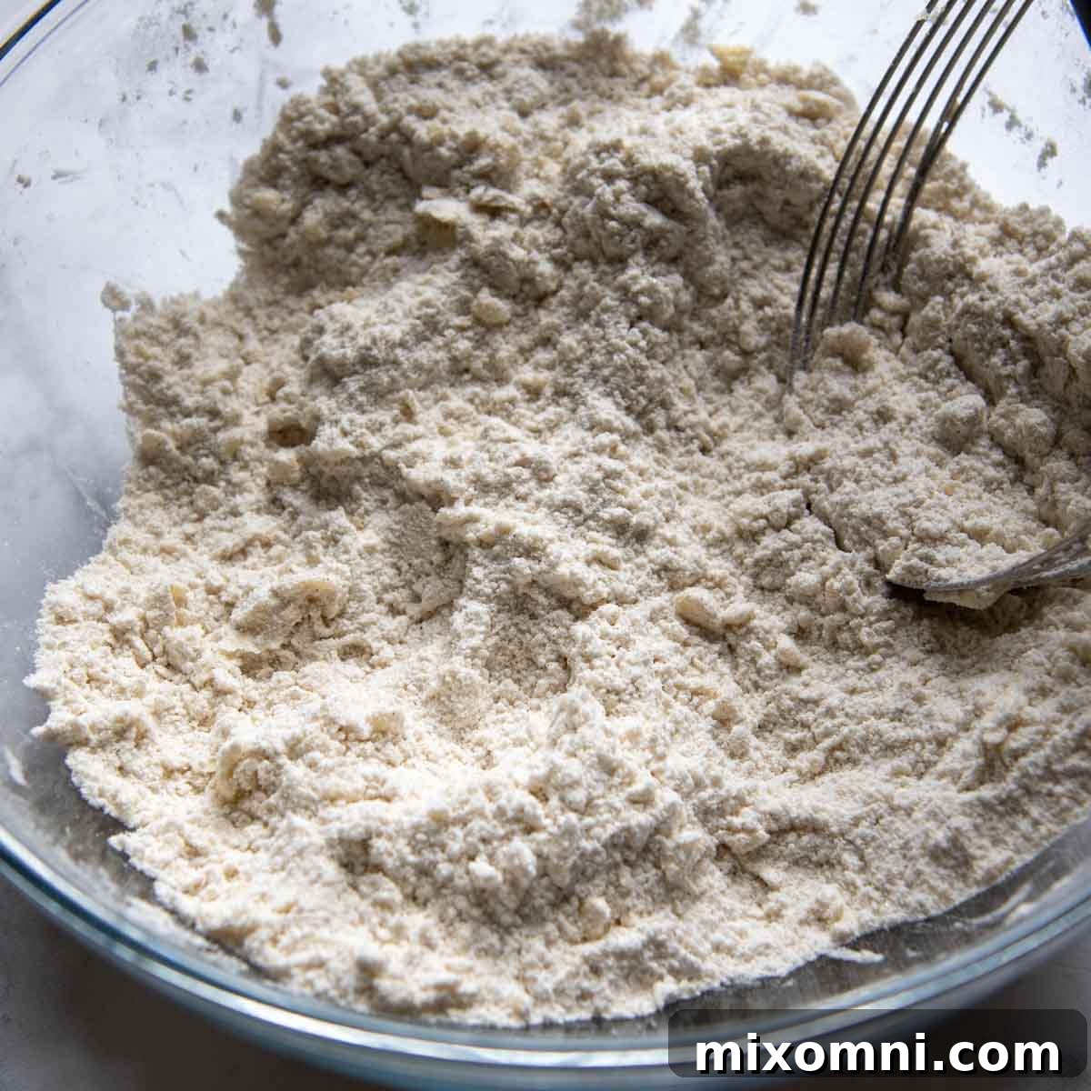 A pastry blender cutting cold butter into dry gluten-free ingredients.