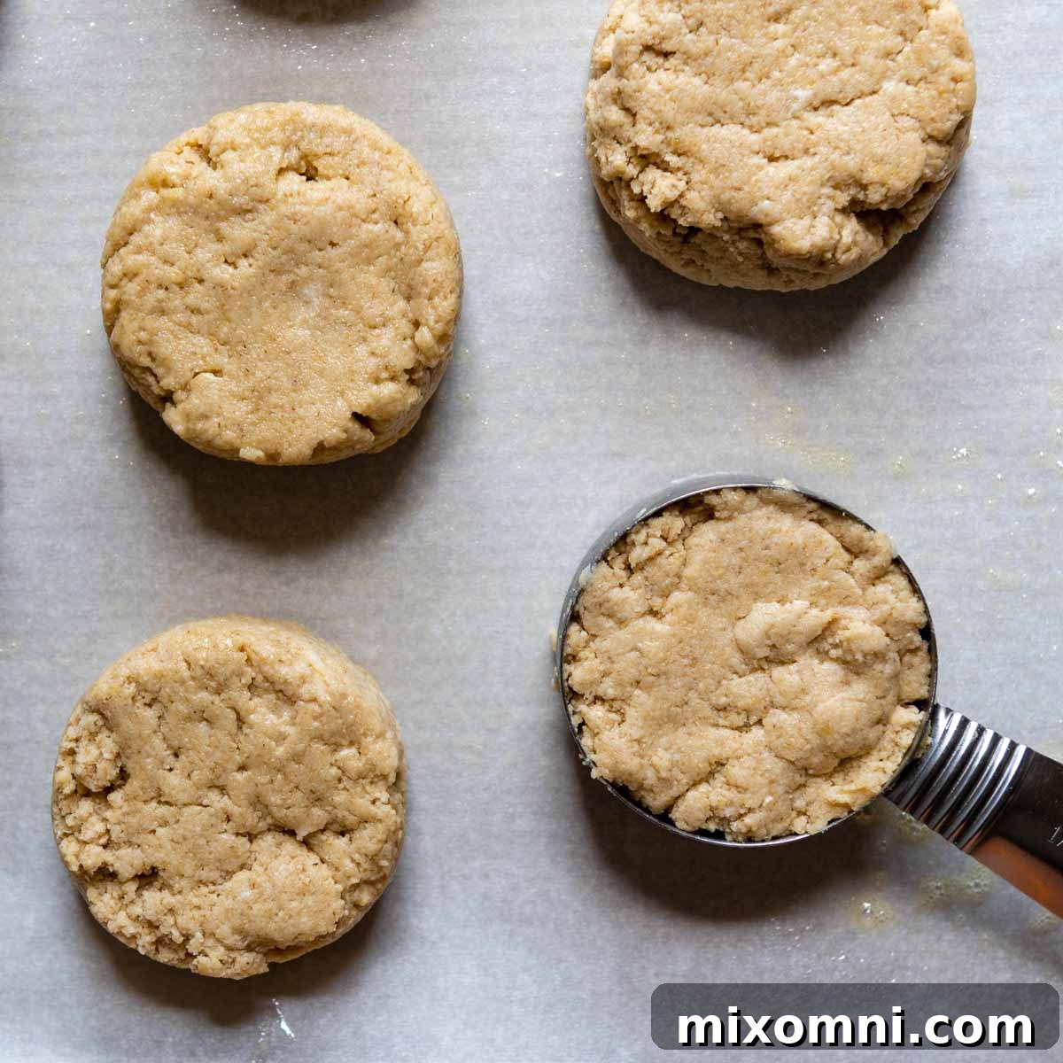 Portioned oat flour biscuit dough dropped onto a baking sheet, ready for the oven.