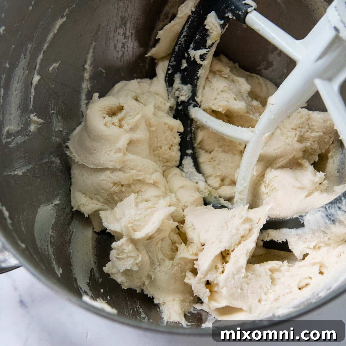 Gluten-free dough in a mixing bowl after being fully combined, appearing stiff and ready for the next step.