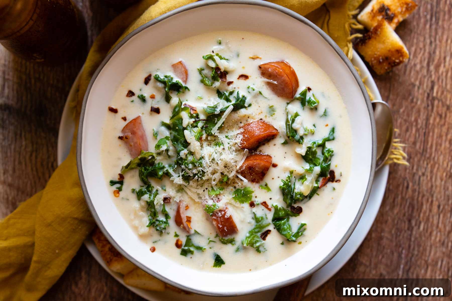 bowl of soup on a wood surface with a gold napkin.