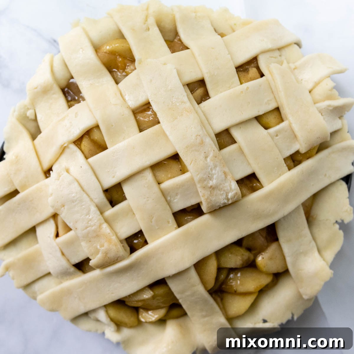 The lattice weaving process continuing, showing the pattern taking shape on the pie.