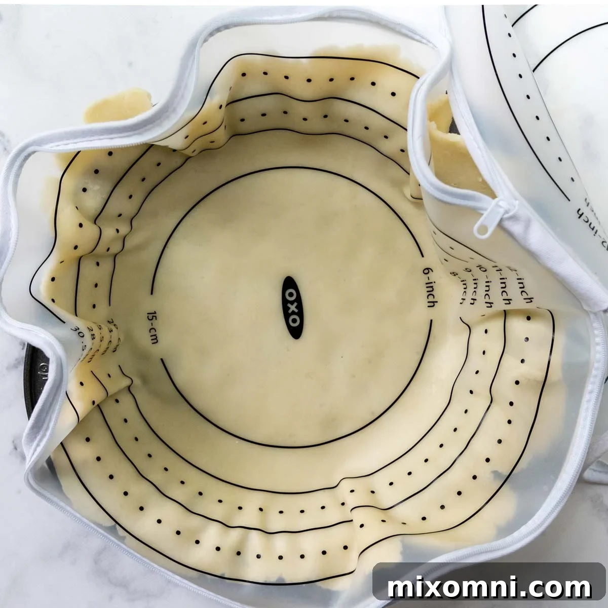 The rolled out pie crust carefully placed and shaped into a pie dish.