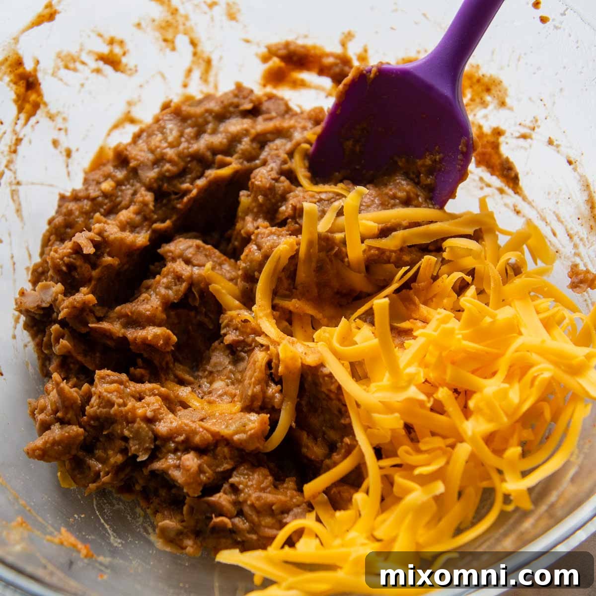 cheese being stirred into bean mixture.