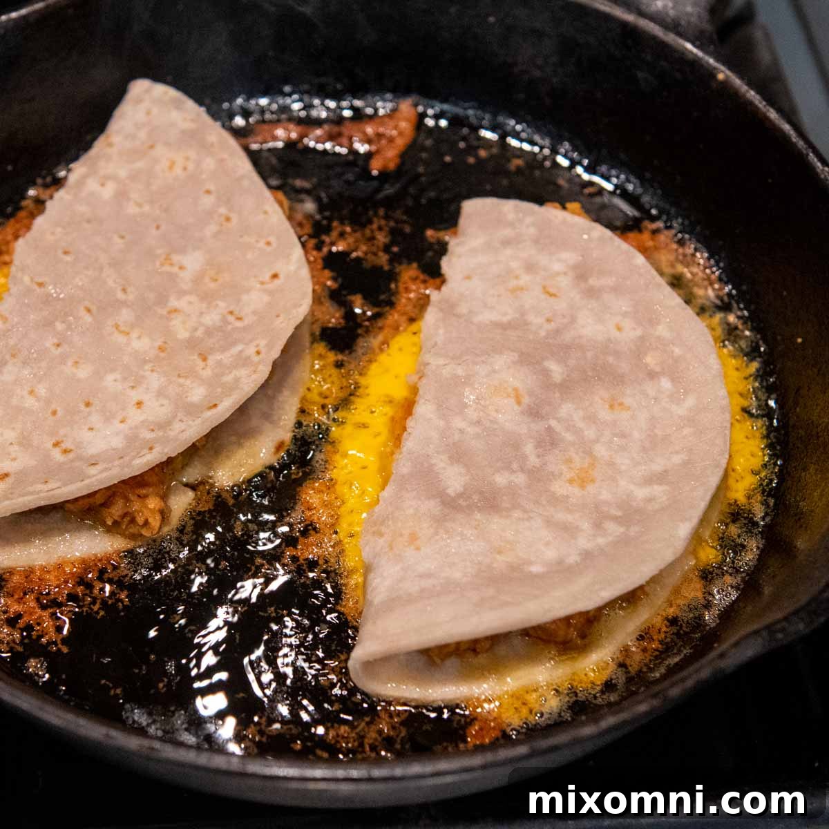 a frying pan cooking quesadillas.