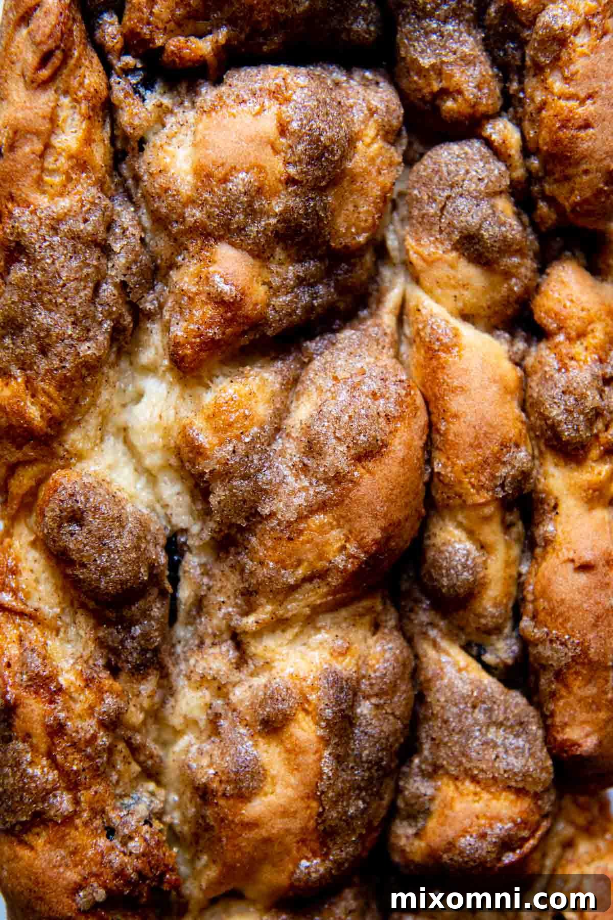 Close up of a golden-brown gluten-free cinnamon raisin bread with a distinct cinnamon swirl on top.