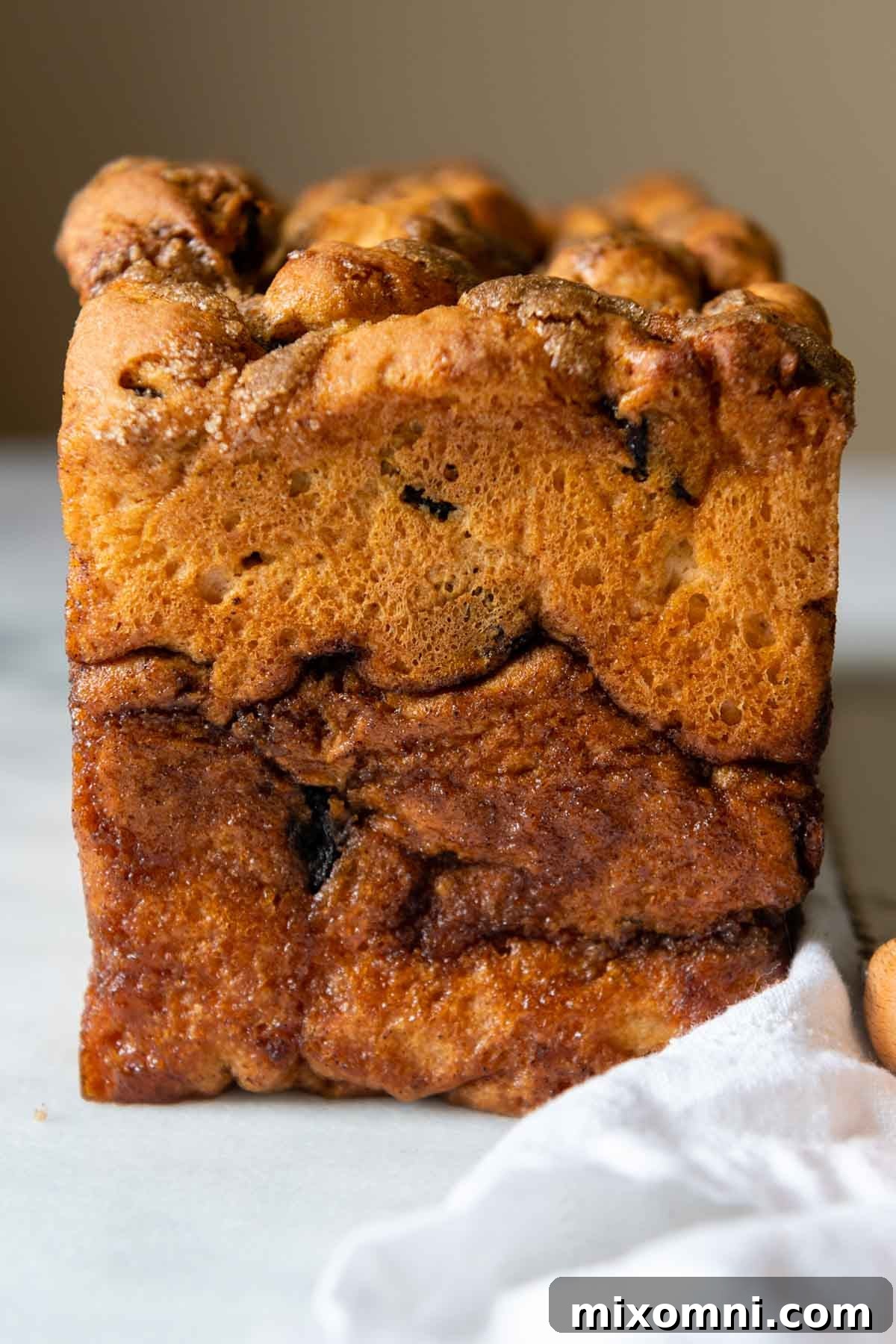The end of a freshly baked gluten-free cinnamon raisin bread loaf, showing its soft interior and perfectly baked crust.