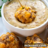 a GF sausage ball being dipped into honey mustard sauce.